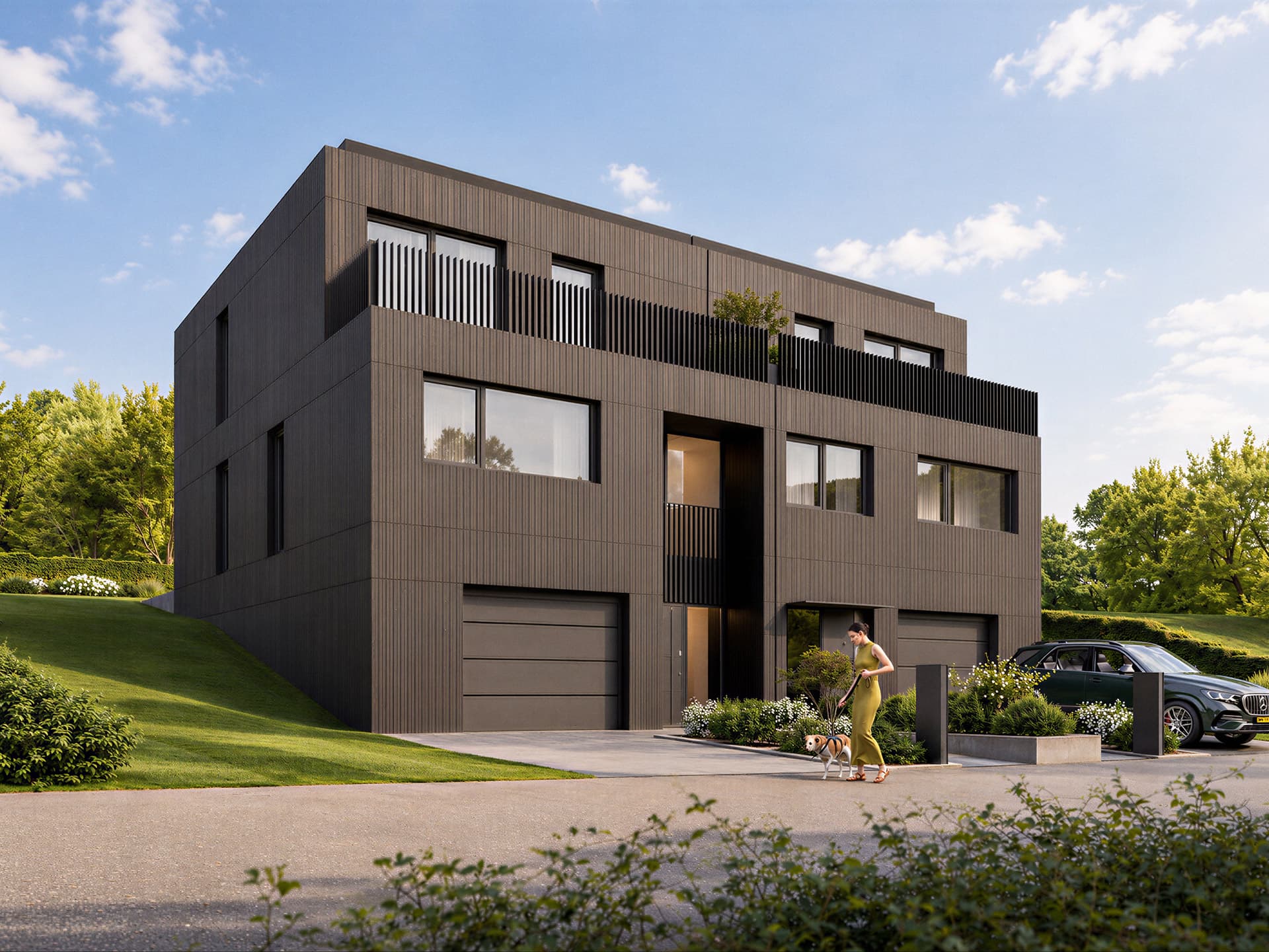 Maison Op Pelgert à Oberanven, façade avant : bardage vertical sombre, deux portes de garage et terrasse à l'étage.